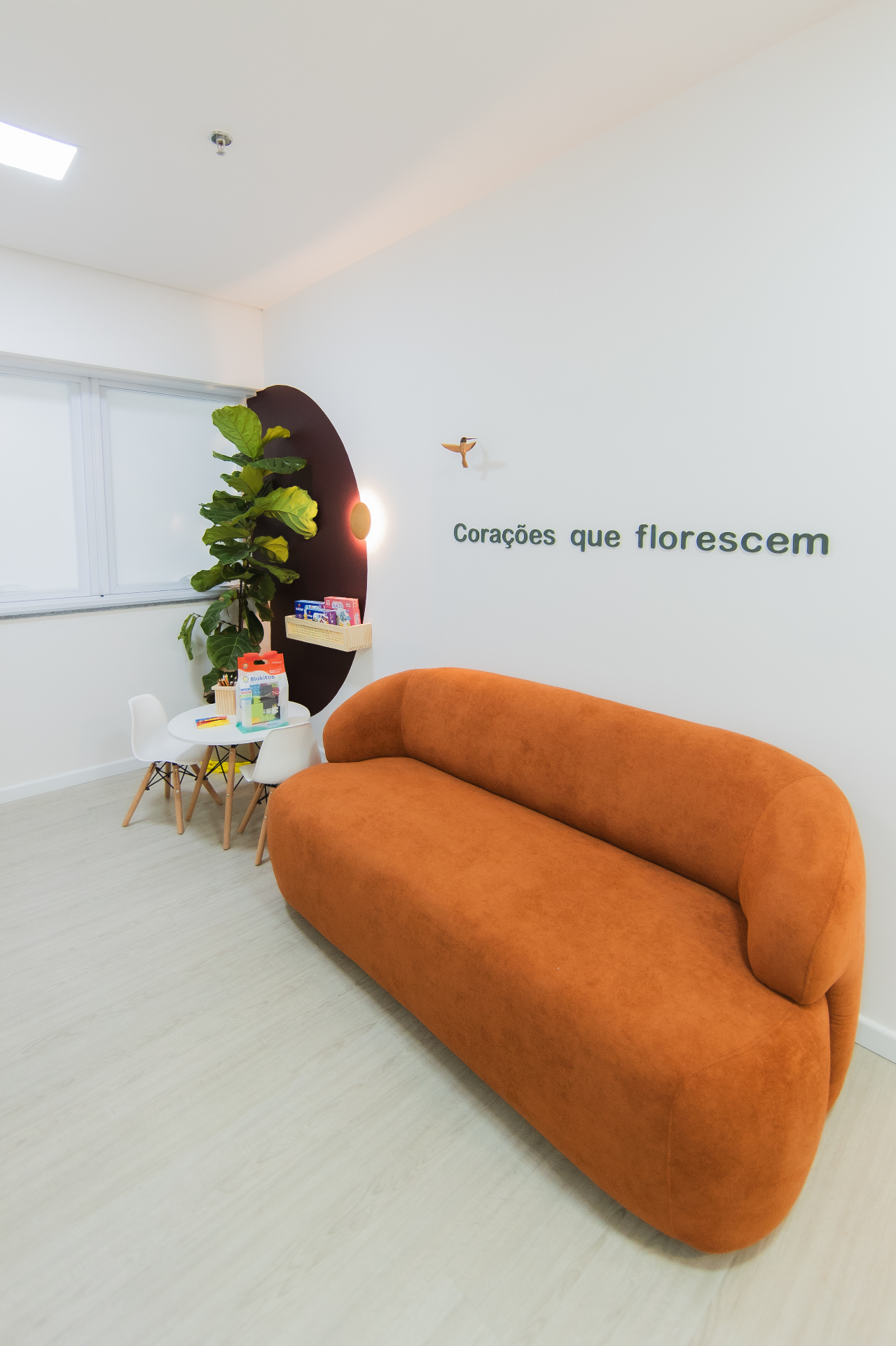 Recepção da Clínica Amiata com sofá acolhedor e espaço infantil